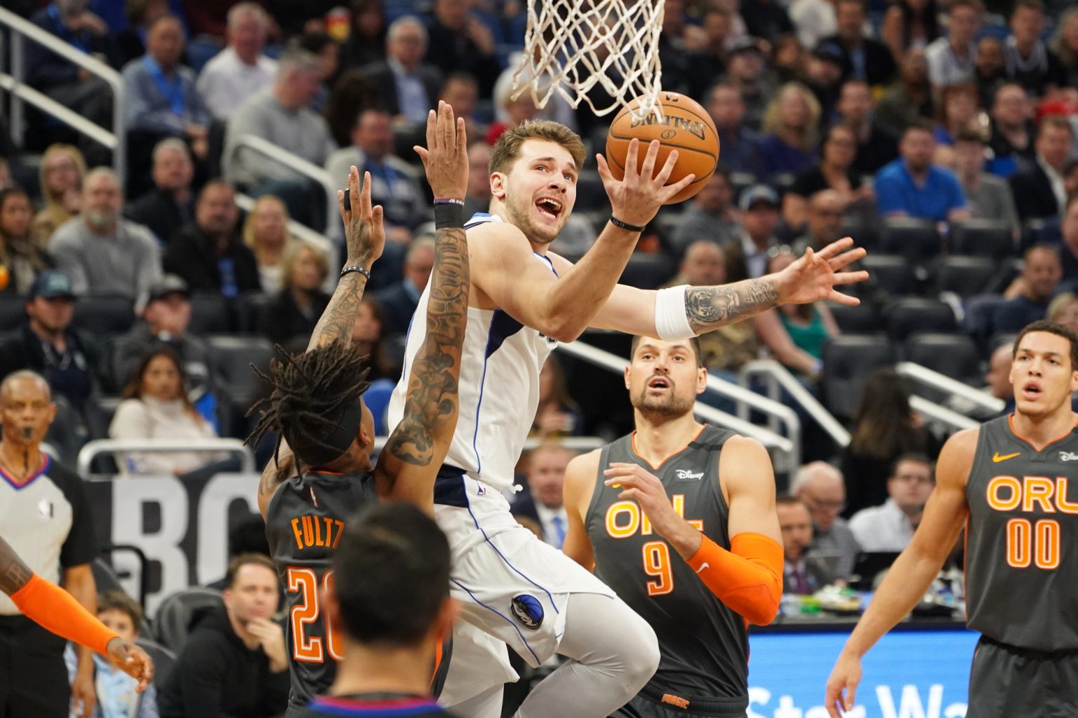 Joueurs de NBA en action sur un parquet illuminé pendant un match de Playoffs